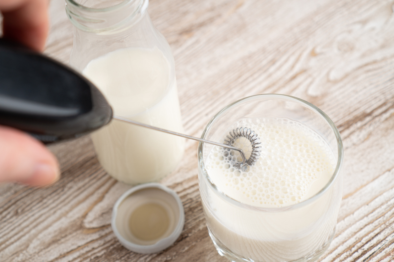 persoon die melk opschuimt